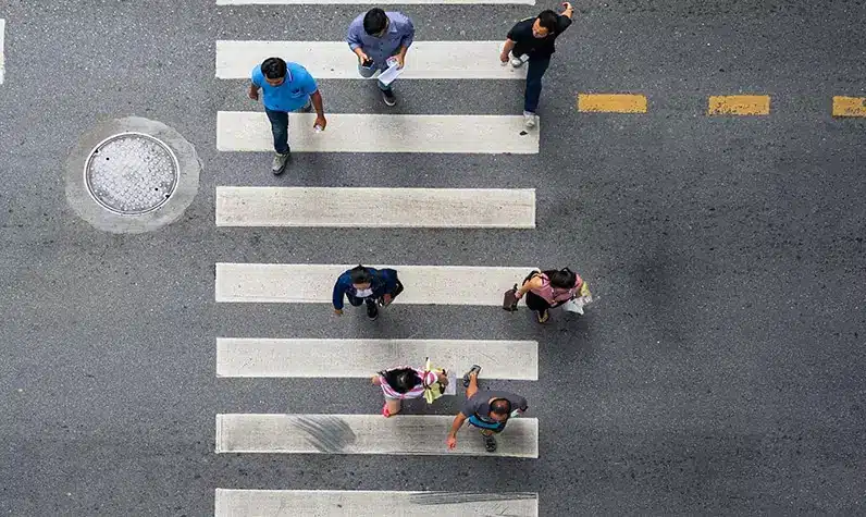 a group of people walking on the crosswalk