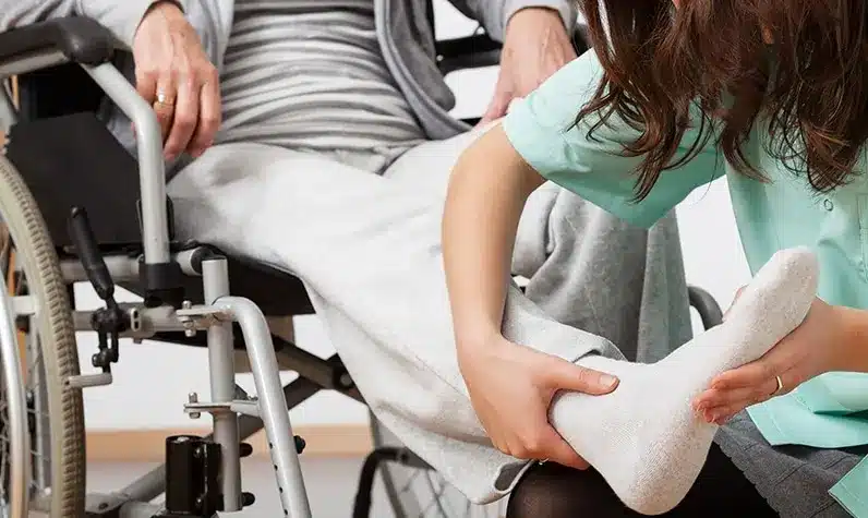 a woman hold the leg of an injured person