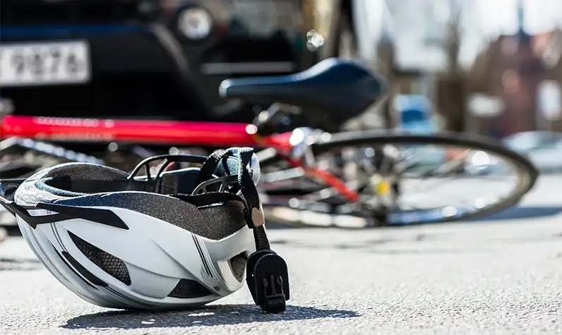 a helmet and a bicycle lying on the road