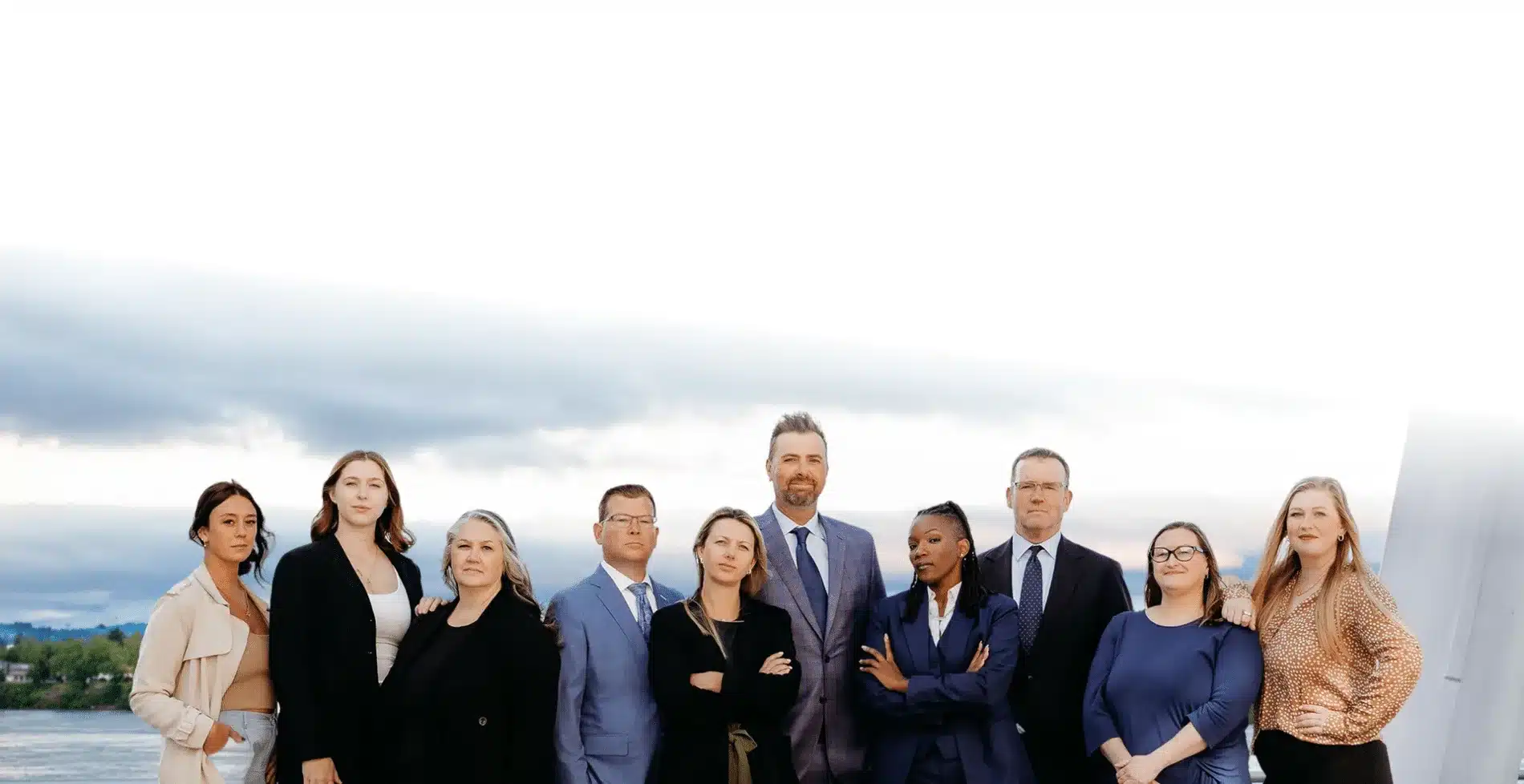 diverse professional team philbrook law stands outdoors under a cloudy sky facing the camera with welcoming expressions
